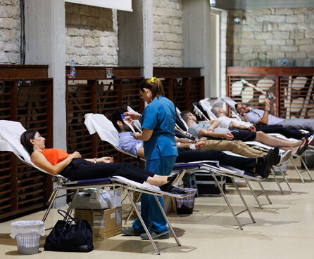 People lying in beds donating blood