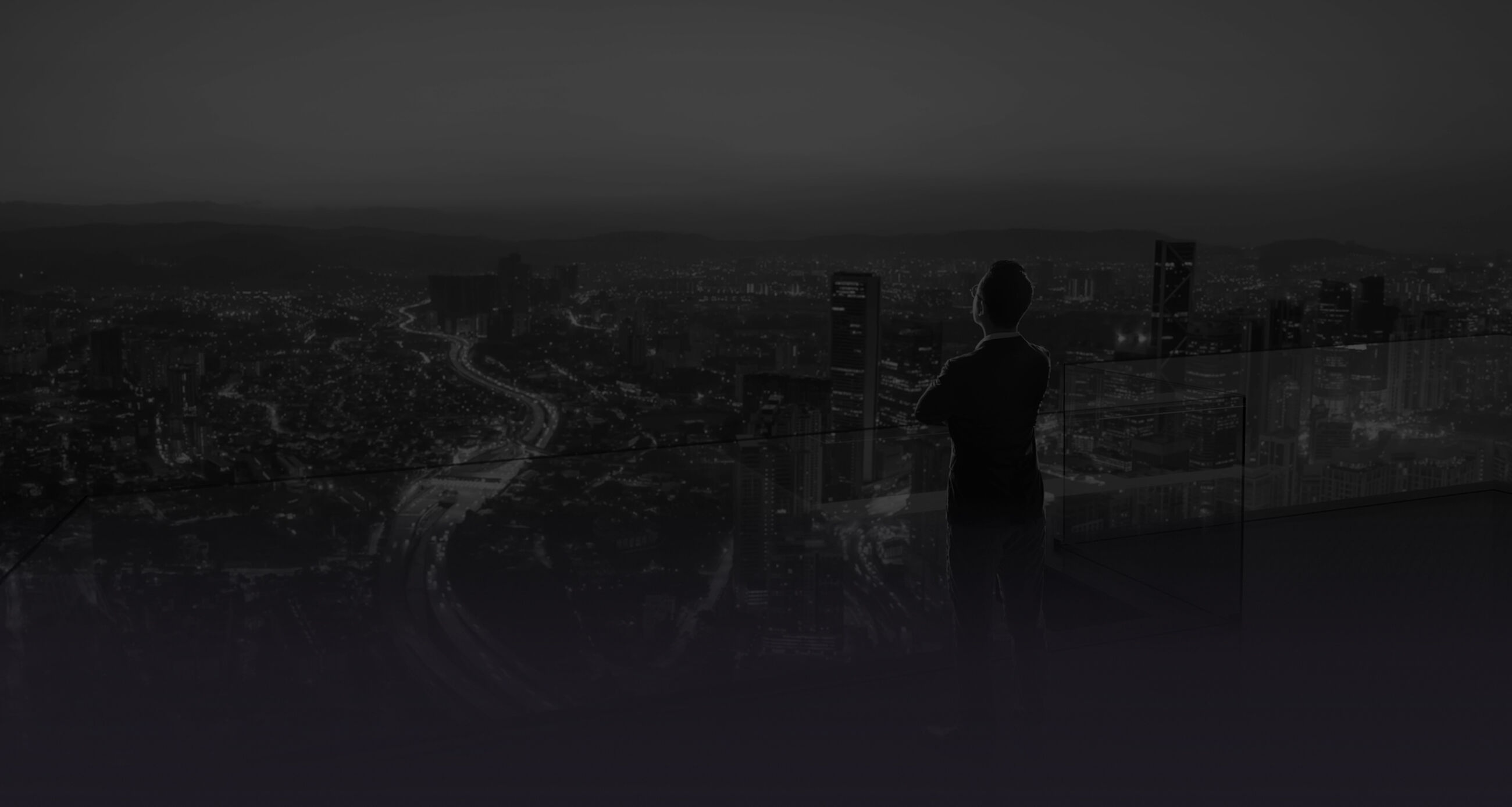 Businessman standing on open roof top balcony watching city night view