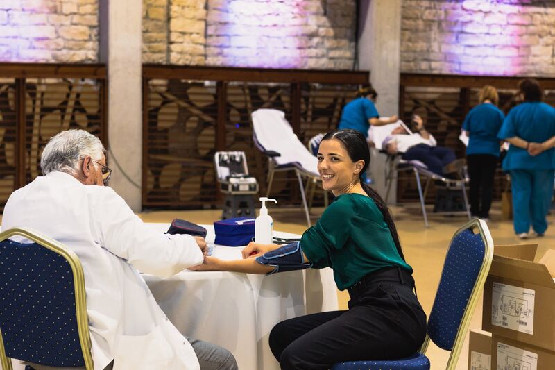Doctor checking woman's heart pressure for blood donation
